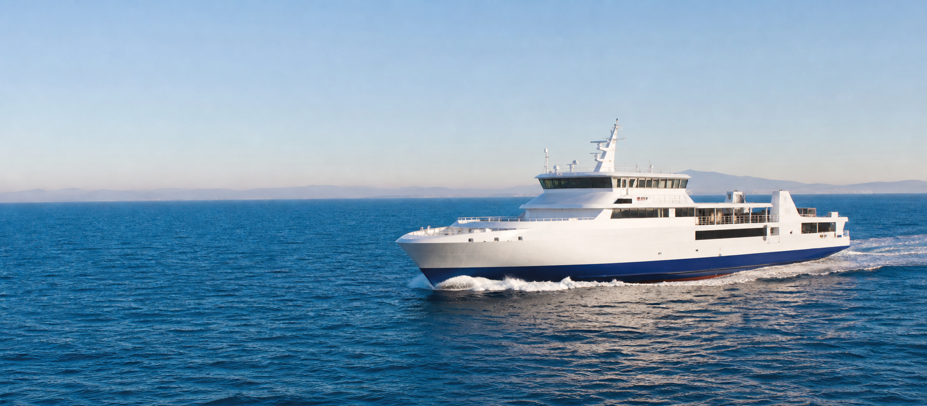 A white passenger-and-car ferry crossing calm deep-blue Mediterranean water