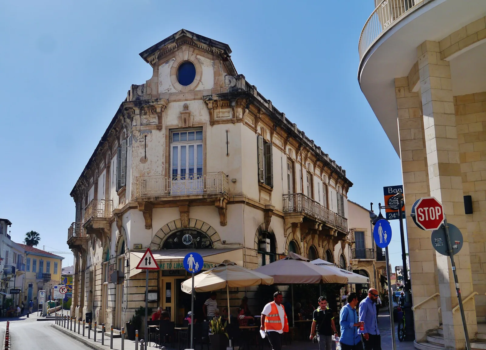 Historic corner building with balconies on a sunny street in Limassol Old Town