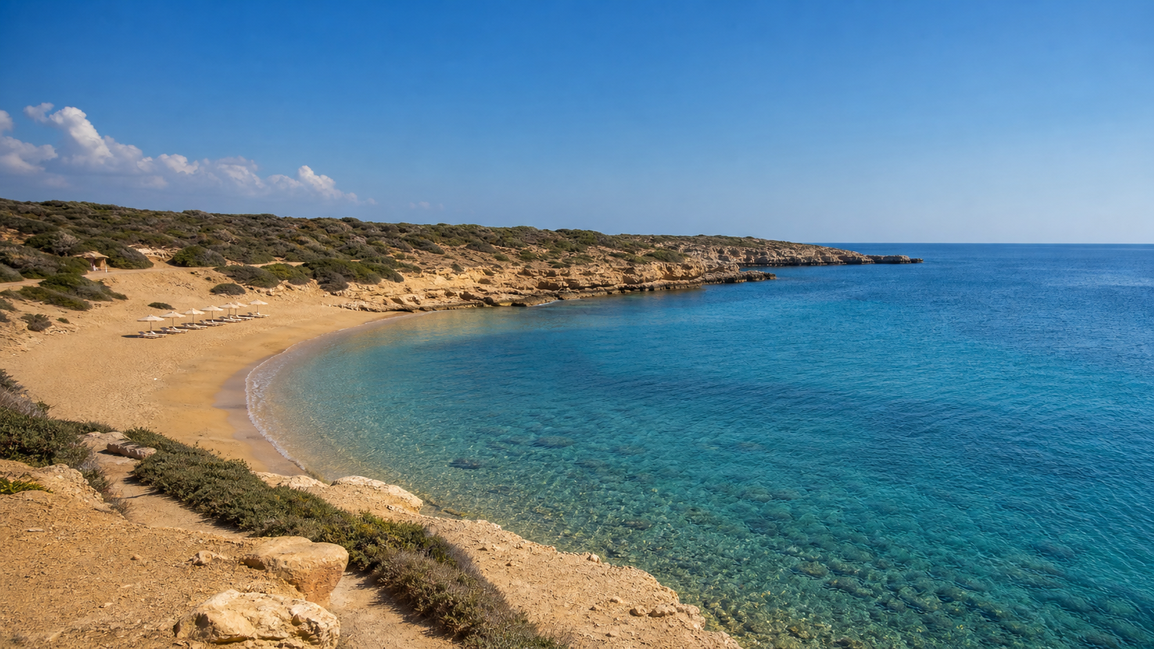 A quiet golden-sand bay with clear blue Mediterranean water on the Paphos coast